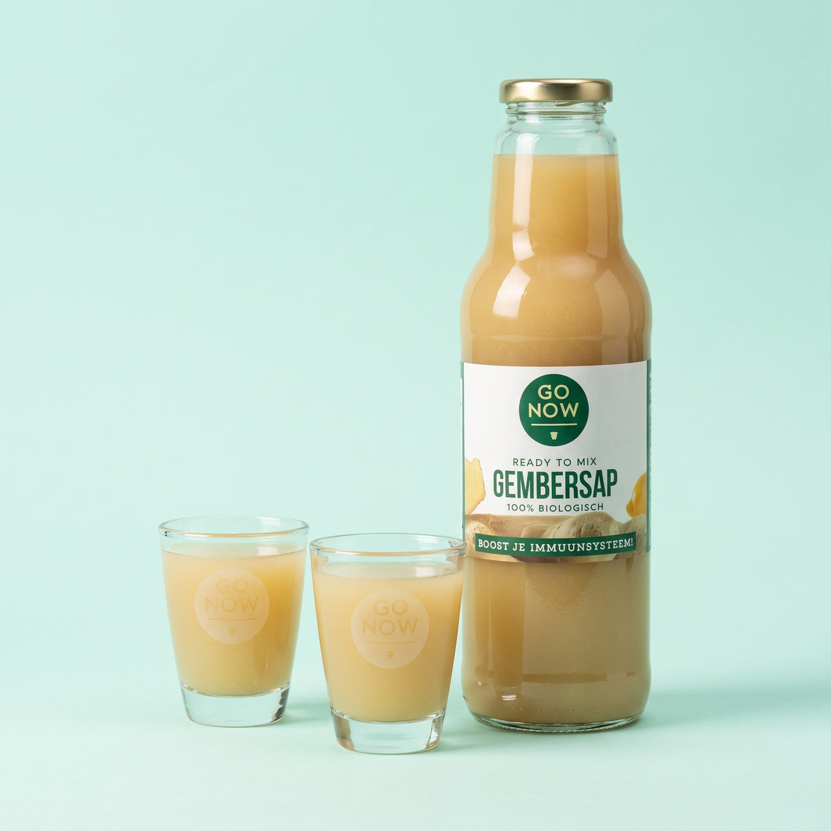 Twee Go Now shotglazen met gembersap naast een fles Pure Gembersap 750ml