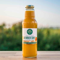 Fles Go Now Gember Shot 750ml met mandarijn en gember, buiten op een houten tafel