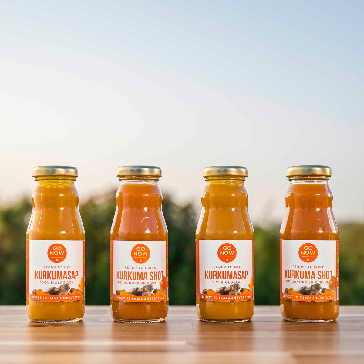 Proefpakket 4-in-1 kurkuma: twee Kurkuma Shots en twee flesjes Pure Kurkumasap 200ml op tafel