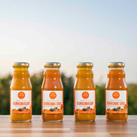 Proefpakket 4-in-1 kurkuma: twee Kurkuma Shots en twee flesjes Pure Kurkumasap 200ml op tafel